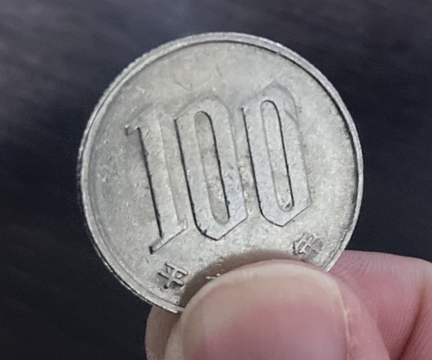 100円玉をつまむ画像